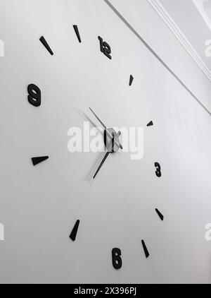 Design minimalista dell'orologio da parete con numeri neri. Foto Stock