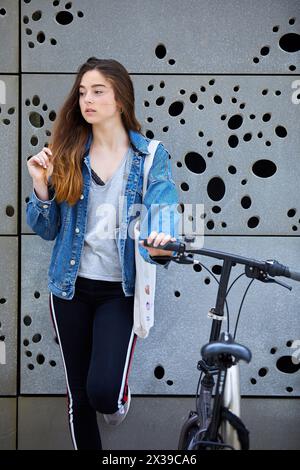 Ragazza giovane con la bicicletta, esterni di San Telmo Museum, Donostia, San Sebastian, Gipuzkoa, Paesi Baschi Foto Stock