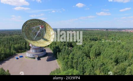 MOSCA - JUL 25, 2015: Antenna TNA 1500 del radiotelescopio RT-64 Bear Lakes tra la foresta durante il giorno di sole estivo. Vista aerea Foto Stock