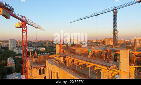 MOSCA - 25 giugno 2015: Le persone lavorano sul cantiere del complesso residenziale Falcon Fort durante la sera estiva al tramonto. Vista aerea Foto Stock