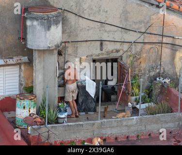 Gli abitanti del posto hanno un cortile povero/giardino sul tetto che si affaccia su un hotel nel centro di Cienfuegos, Cuba Foto Stock