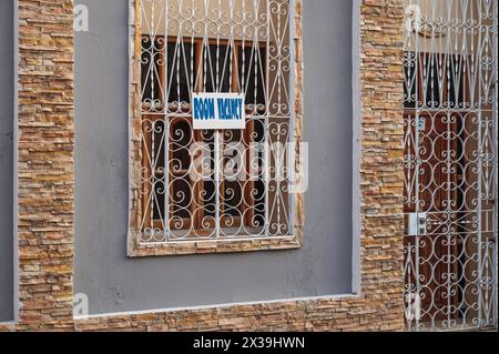 Un albergo pulito e ordinato con griglie in ferro battuto ornate su porte e finestre, che pubblicizza la "camera vacante" a Cienfuegos, Cuba Foto Stock