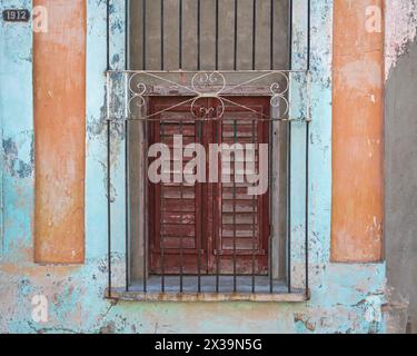 Una tipica vecchia proprietà fatiscente, spesso ancora abitata, che fiancheggia le strade secondarie di Cienfuegos, Cuba Foto Stock