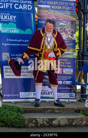 Uomo piangere e fattorino (premiato con la medaglia del vincitore del primo premio) che fa un annuncio pubblico rumoroso - Ilkley, West Yorkshire, Inghilterra Regno Unito. Foto Stock