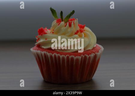 Cupcake in velluto rosso. Le torte finite sono sul tavolo. Decorata con foglie di menta. Foto Stock