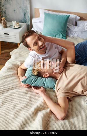 Una coppia gay amorevole che si rilassa su un letto in un abbigliamento informale. Foto Stock