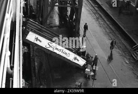 Anni '1960, storici, i passeggeri che salgono su una linea, tramite una passerella al molo di Southampton, Inghilterra, Regno Unito. Il nome sullo striscione è Safmarine, abbreviazione di South African Marine Corporation, una compagnia di navigazione sudafricana. Fondata nel 1946, la società offriva navi merci, merci e container e dal 1965 al 1977 gestiva un servizio di linea passeggeri tra il Regno Unito e il Sud Africa, utilizzando due ex navi della Union-Castle Line, RMS Transvaal Castle e Pretoria Castle. Foto Stock