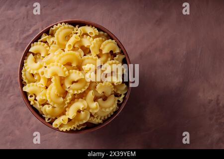 Creste di Gallo crudo in Clay Bowl su sfondo marrone, Copy Space Foto Stock