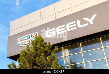 Samara, Russia - 16 aprile 2024: Showroom auto di un marchio cinese Geely. Cartello ufficiale della concessionaria di Geely sul muro dell'edificio degli uffici Foto Stock