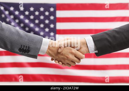 Uomini d'affari che stringono la mano davanti a una bandiera degli Stati Uniti Foto Stock