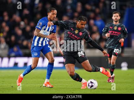 Joao Pedro di Brighton e Hove Albion (a sinistra) e Manuel Akanji di Manchester City si battono per il pallone durante la partita di Premier League all'American Express Stadium di Brighton. Data foto: Giovedì 25 aprile 2024. Foto Stock