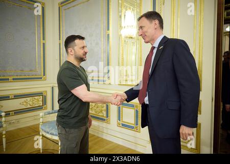 Kiev, Ucraina. 25 aprile 2024. Il presidente ucraino Volodymyr Zelenskyy, a sinistra, dà il benvenuto al Cancelliere britannico dello Scacchiere Jeremy Hunt, a destra, prima di un incontro bilaterale al Palazzo Mariinsky, 25 aprile 2024, a Kiev, Ucraina. Credito: Presidenza Ucraina/Ufficio stampa presidenziale ucraino/Alamy Live News Foto Stock