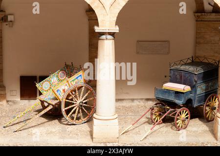Vista del cortile interno del Palazzo reale di Palermo con le tradizionali vecchie carrozze sotto il portico (Palermo, Sicilia) Foto Stock