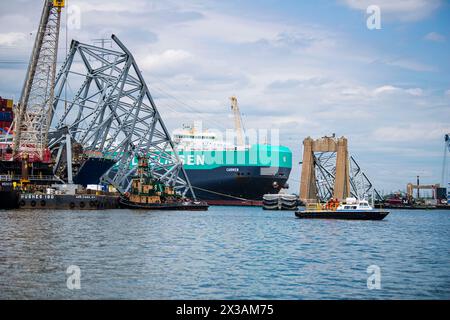 Dundalk, Stati Uniti d'America. 25 aprile 2024. Dundalk, Stati Uniti d'America. 25 aprile 2024. La portaerei danese Carmen, si muove attraverso un canale temporaneo oltre i rottami del Ponte delle chiavi crollato quando il porto di Baltimora fu riaperto il 25 aprile 2024, vicino a Dundalk, Maryland. Il ponte è stato colpito dalla nave container MV Dali da 984 piedi il 26 marzo e crollò uccidendo sei lavoratori. Credito: PO2 Ronald Hodges/Guardia Costiera degli Stati Uniti/Alamy Live News Foto Stock