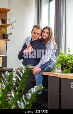 Una coppia condivide un momento tenero in una stanza accogliente, le donne si abbracciano gentilmente suggerendo una relazione premurosa, evidenziando San Valentino . Alta qualità Foto Stock