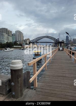 Il litorale del porto di Sydney si affaccia sul famoso ponte del porto di Sydney in una giornata nuvolosa Foto Stock