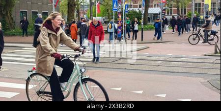 AMSTERDAM, NETHLANDS - 25 APRILE 2024 - le persone viaggiano in bicicletta in una strada di Amsterdam, Paesi Bassi, 25 aprile 2024. Foto Stock