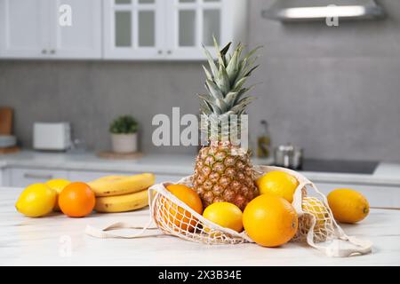 Sacchetto con spago con frutta fresca su un tavolo leggero in cucina Foto Stock