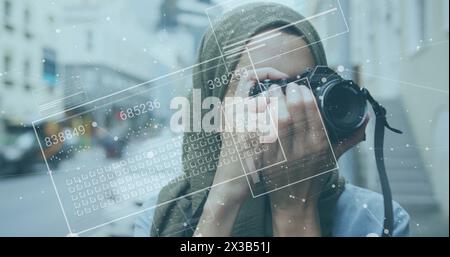 Immagine dell'elaborazione di dati finanziari su una donna birazziale in hijab che scatta foto Foto Stock