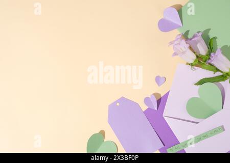 Supporti in carta come cuori, buste e carta con spazio per le copie. Bellissimi fiori e una piccola carta con il testo “a tutte le donne nella W Foto Stock