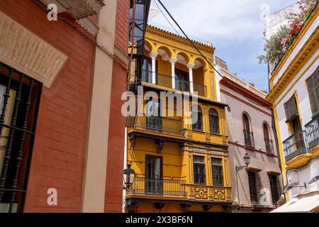 Edificio storico con facciata gialla e decorazioni sui balconi, centro di Siviglia, juderia, Siviglia, Andalusia, Spagna Foto Stock