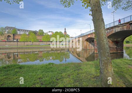 Vecchio ponte costruito nel 1549 sulla Saar con castello, chiesa del castello e fortificazioni storiche della città, mura della città, riflessi, tronco d'albero, Saarbruecken Foto Stock