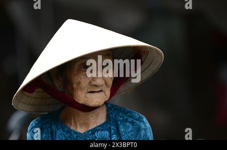 Ritratto di un'anziana donna vietnamita scattata in un mercato locale a Hội An, Vietnam. Foto Stock
