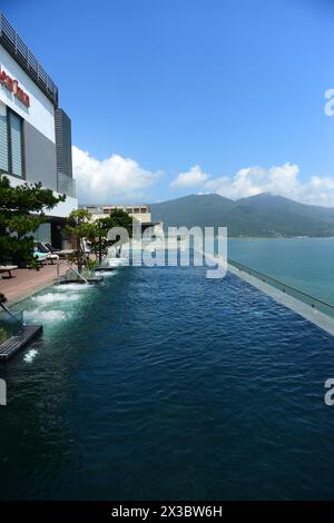 Una splendida vista della costa e del mare con la piscina a sfioro sul tetto dell'Hilton Garden Inn a da Nang, Vietnam Foto Stock