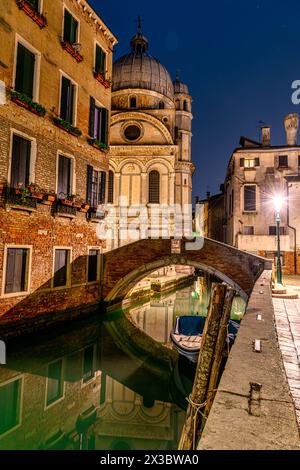 Un pittoresco canale laterale stretto a Venezia di notte. Foto Stock