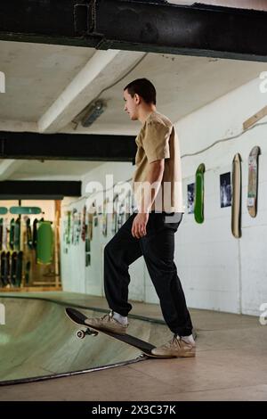 Colpo lungo verticale del giovane caucasico attivo che si prepara a eseguire il trick mentre si allena lo skateboard nello skatepark Foto Stock