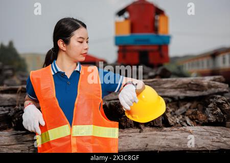 ingegnere donna che guarda il treno di manutenzione del servizio di orologio da polso in deposito ferroviario. l'orario di lavoro controlla l'orario di lavoro. Foto Stock