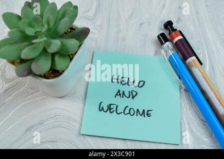 Concetto di Hello and Welcome scrivere su appunti adesivi isolati su un tavolo di legno. Foto Stock