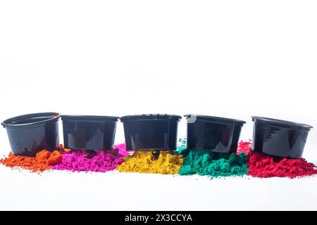 Polvere colorata holi in secchi in plastica nera isolati su sfondo bianco. Foto Stock
