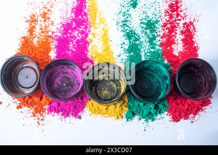 Polvere colorata di holi su sfondo bianco e piccole scatole nere vuote sopra di esso Foto Stock