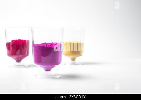 Polvere di holi multicolore in vetro isolata su sfondo bianco. Holi Powder è un tradizionale festival indiano. Primo piano Foto Stock