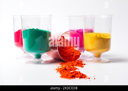 Polvere colorata di holi in misurini su sfondo bianco con spazio di copia Foto Stock