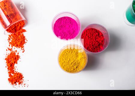 Polvere colorata di holi in vasetti di vetro su sfondo bianco, vista dall'alto Foto Stock