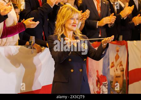 Alcoy, Spagna, 04-19-2024: Direttore dell'inno dei festeggiamenti di Alcoy Blanca Carbonell di fronte al municipio tribuno che mostra il testimone ricevuto da Foto Stock