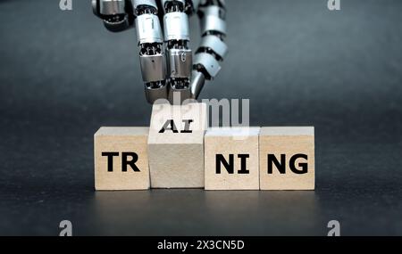 La mano del robot trasforma il cubo di legno e mette le lettere ai (intelligenza artificiale) alla parola training. Foto Stock