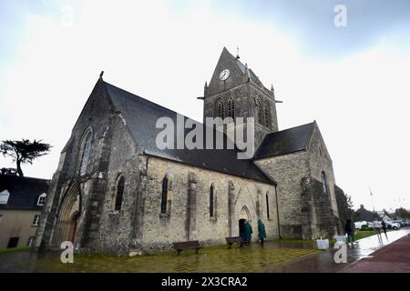 Questa fotografia scattata il 25 aprile 2024 mostra la chiesa di Sainte-Mere-Eglise, nel nord-ovest della Francia, dove è appeso un manichino raffigurante un paracadutista. Un paracadutista americano, John Marvin Steele 1912-1969, sbarcò sul pinnacolo della torre della chiesa a Sainte-Mere-Eglise, primo villaggio ad essere liberato dall'esercito degli Stati Uniti durante l'operazione Overlord il 6 giugno 1944. A giugno, la Francia terrà una cerimonia per celebrare il 80° anniversario degli sbarchi in Normandia del 1944, noti anche come sbarchi del D-Day lungo le spiagge della Normandia, un'operazione che ha gettato le basi della vittoria alleata sulla W Foto Stock