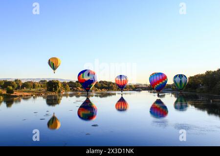 Salita all'alba di palloncini vibranti sull'acqua Foto Stock