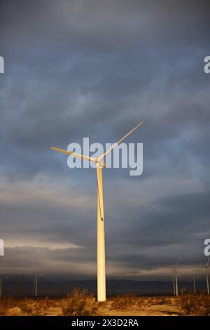 Turbina eolica solitaria sotto un cielo tempestoso al crepuscolo Foto Stock