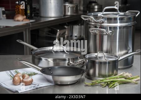 Set di utensili da cucina in acciaio inox con verdure fresche sul tavolo dello chef Foto Stock