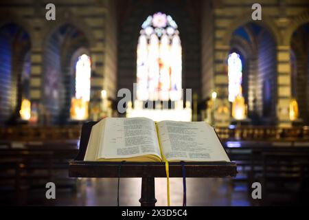 Dettaglio del libro sacro aperto sul leggio in legno in un tempio religioso, vista frontale. Foto Stock