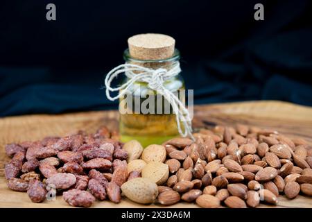 Mandorle (Prunus dulcis, Prunus amygdalus, Amygdalus communis, Amygdalus dulcis), mandorle arrostite, con guscio e olio di mandorle crudo Foto Stock