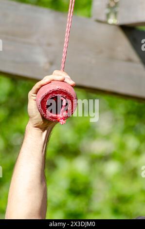 Dettaglio della mano di un atleta su un ostacolo sospeso in una corsa ad ostacoli, OCR. Gare sportive estreme Foto Stock