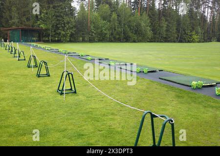 Area di partenza con cesti e palle sul campo da golf in caso di pioggia Foto Stock