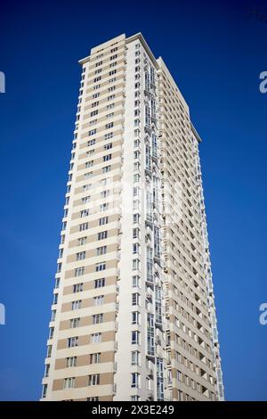 Alto e moderno edificio che si affaccia su un cielo azzurro. Foto Stock