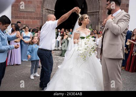 Gli sposi novelli emergono dalla Cattedrale di se per essere ricoperti di riso e petali di rosa durante un matrimonio di famiglia portoghese presso la Cattedrale di se, il 20 aprile 2024, a Funchal, Madeira, Portogallo. Foto Stock