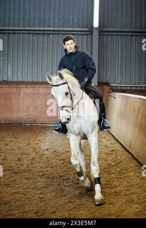 Cavalcate a cavallo bianco nell'arena coperta. Foto Stock